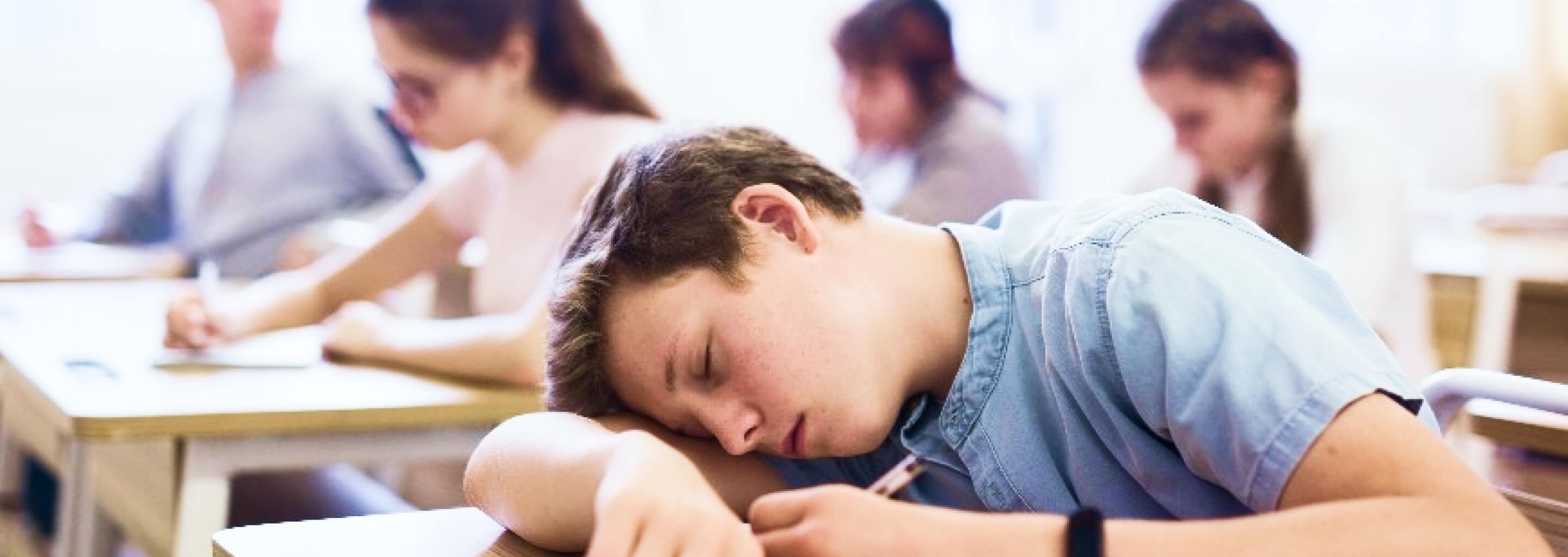 ragazzo che si addormenta sul banco di scuola