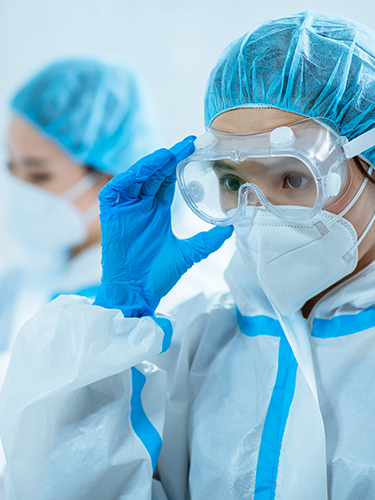 female medical worker wear protective suits and ready to take care of coronavirus patient in isolation room