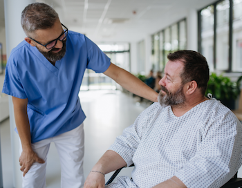 Medico che parla con il paziente su sedia a rotelle