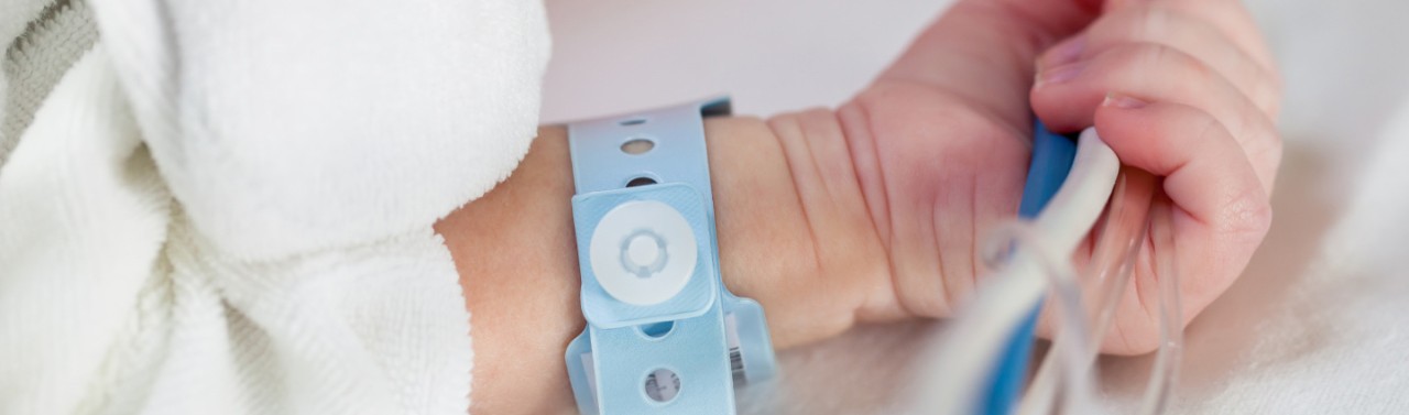 Mano di bambino che tiene i tubi per flebo