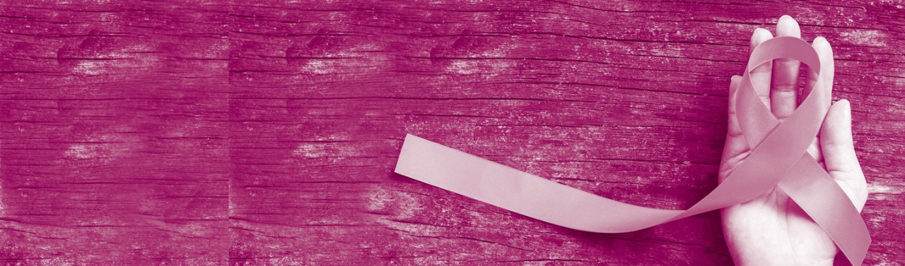 Mano che regge un fiocco rosa su sfondo fucsia