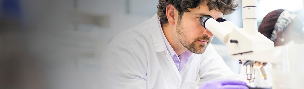 Medico che controlla il microscopio